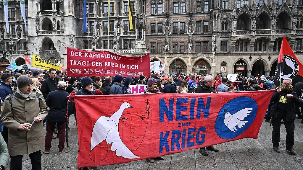Teilnehmende-des-Ostermarsches-ziehen-mit-einem-Plakatdurch-die-Stadt