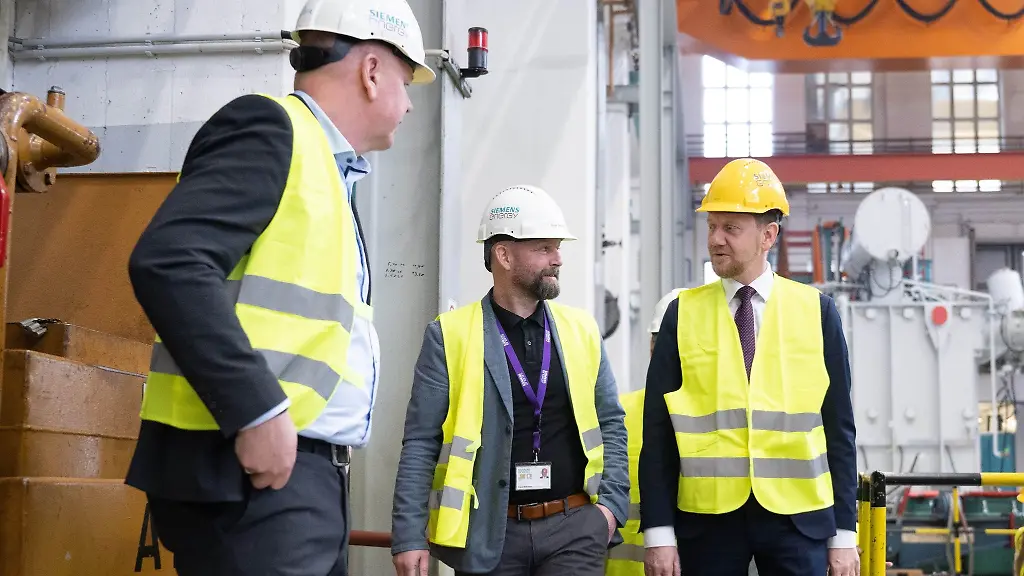 Michael-Kretschmer-r-CDU-Ministerpraesident-von-Sachsen-steht-in-einer-Werkhalle