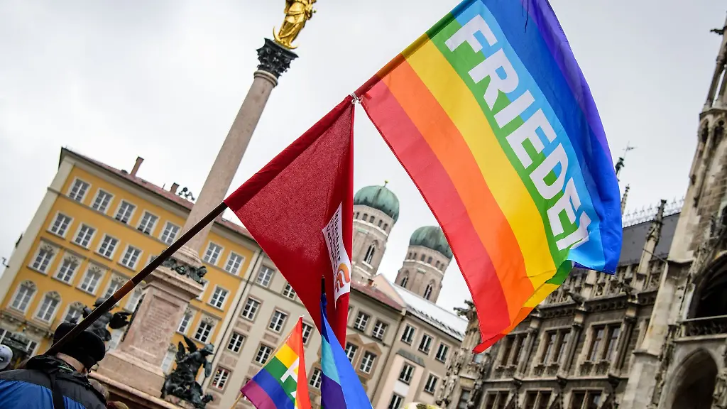 Eine-Regenbogenfahne-mit-der-Aufschrift-Frieden-weht-bei-einem-Ostermarsch