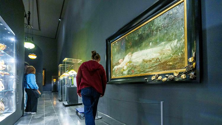 Eine Mitarbeiterin des Museums sichert das Kunstwerk ab, um es vor den Swiftie-Scharen zu schützen.
