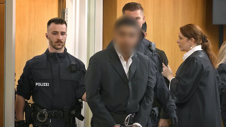 Der Angeklagte wird in den Gerichtssaal geführt.