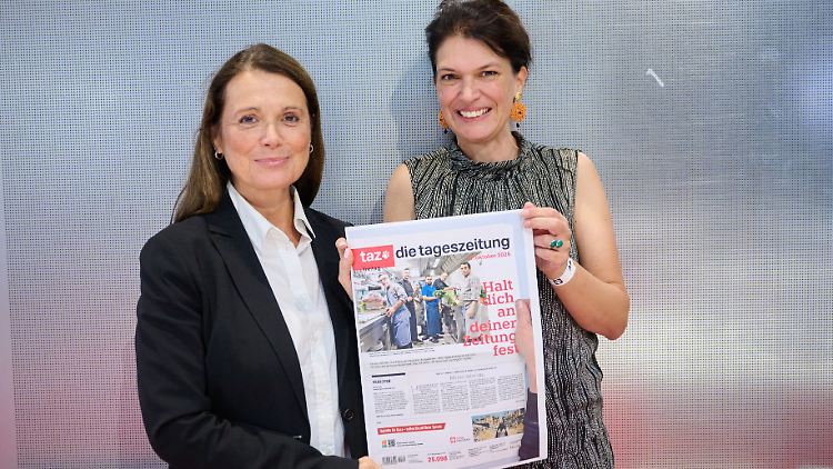 Die beiden Chefredakteurinnen der taz Barbara Junge (l) und Ulrike Winkelmann mit einer Druckfahne der letzten Ausgabe.