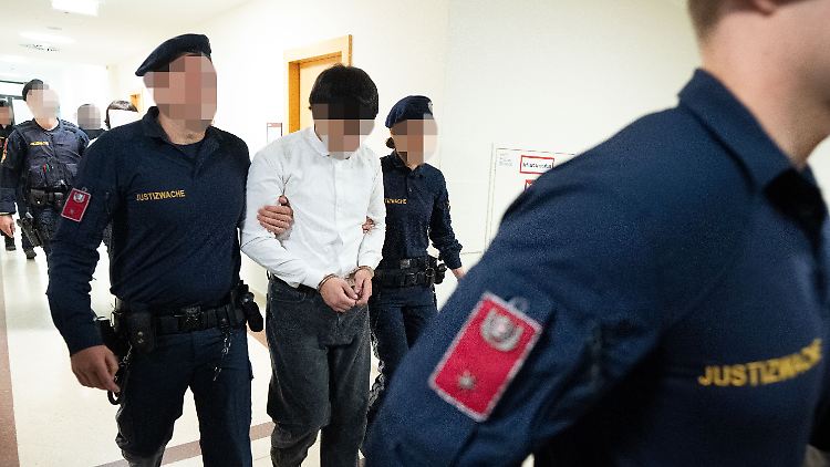 Die Angeklagten auf dem Weg in den Gerichtssaal. 