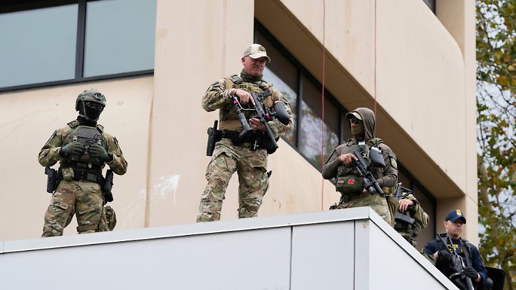 Bewaffnete Sicherheitskräfte bewachen ein Gebäude der US-Einwanderungsbehörde in Portland.