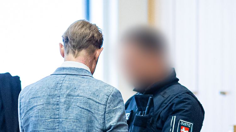 Christian B. im Jahr 2024 mit einem Polizisten in einem Gerichtssaal, inzwischen lebt er in Freiheit.