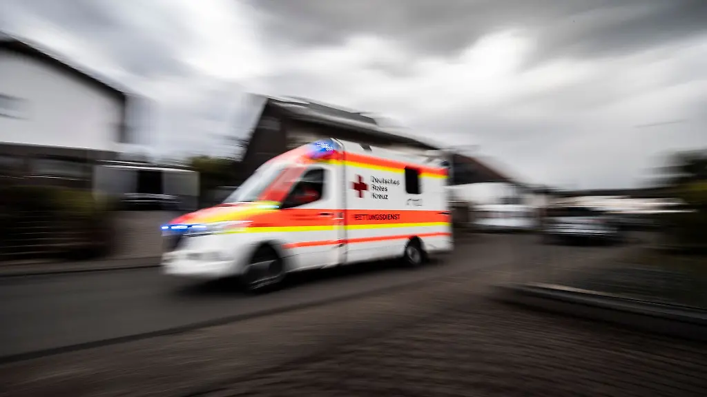 Ein-Rettungswagen-faehrt-ueber-die-Strasse