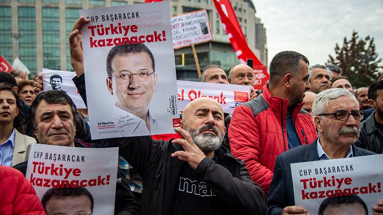 Anhänger des Istanbuler Bürgermeisters Imamoglu halten Bilder mit seinem Konterfei in die Luft.