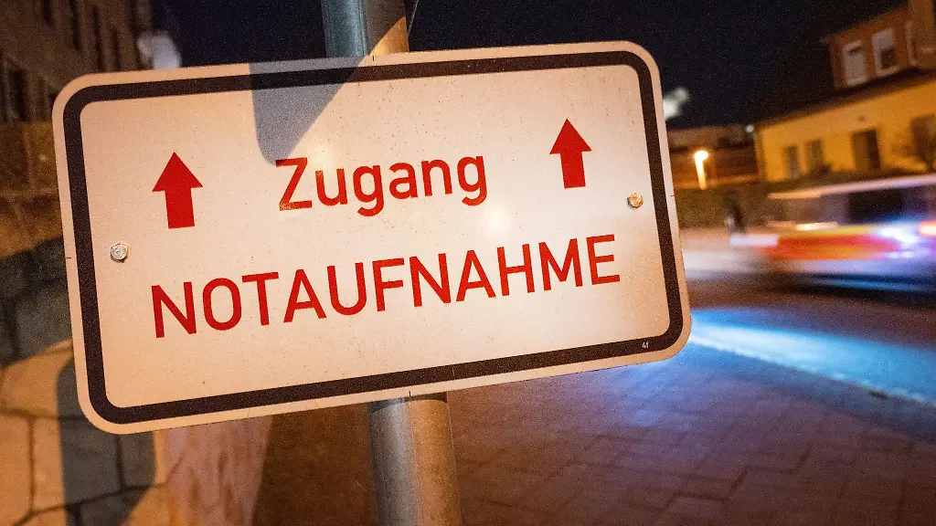 Der-Schriftzug-Zugang-Notaufnahme-haengt-vor-einem-Gebaeude-einer-Klinik