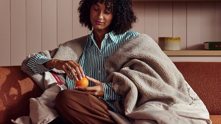 Man legt sich die Stoov Huge Hug 3 um die Schultern, statt sich einfach damit zuzudecken.