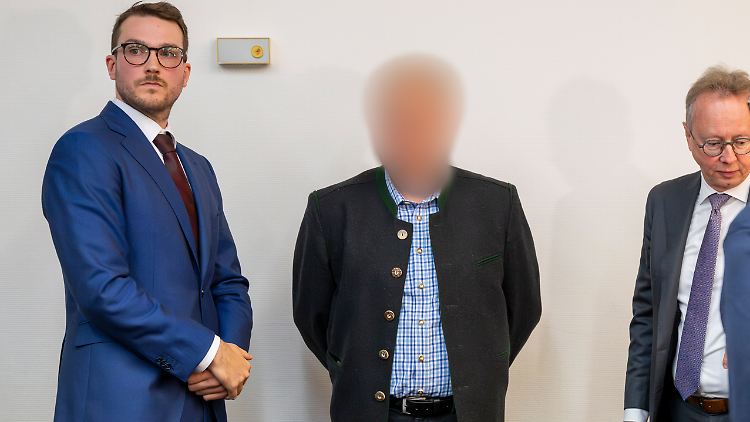 Einer der Angeklagten mit seinen Anwälten zum Prozesauftakt.