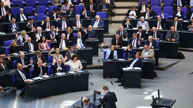 Abgeordnete von CDU, CSU und AfD heben bei einer Abstimmung im Bundestag die Hand.