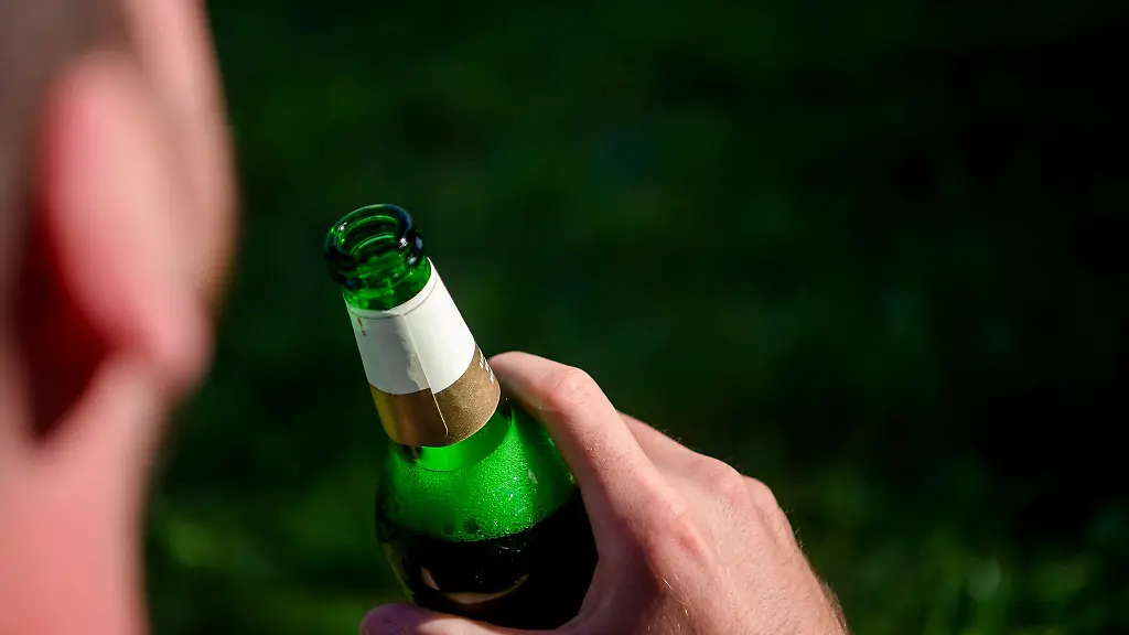 Ein-Mann-haelt-eine-Bierflasche-in-der-Hand