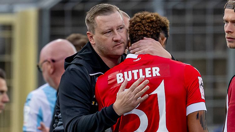 Der Cottbuser Pressesprecher Scharfenberg-Hecht umarmt Butler.