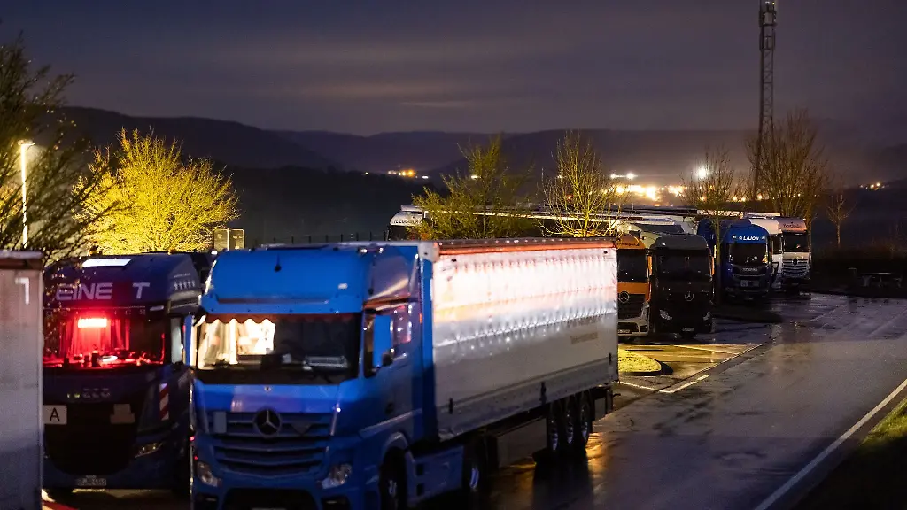 Auf-einemParkplatz-sind-alle-Stellplaetze-fuer-Lkws-belegt-Sie-stehen-zusaetzlich-auf-Parkflaechen-fuer-Autos