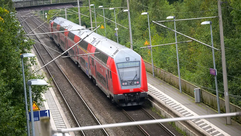 Ein-Regionalzug-der-Deutschen-Bahn-faehrt-durch-einen-Bahnhof