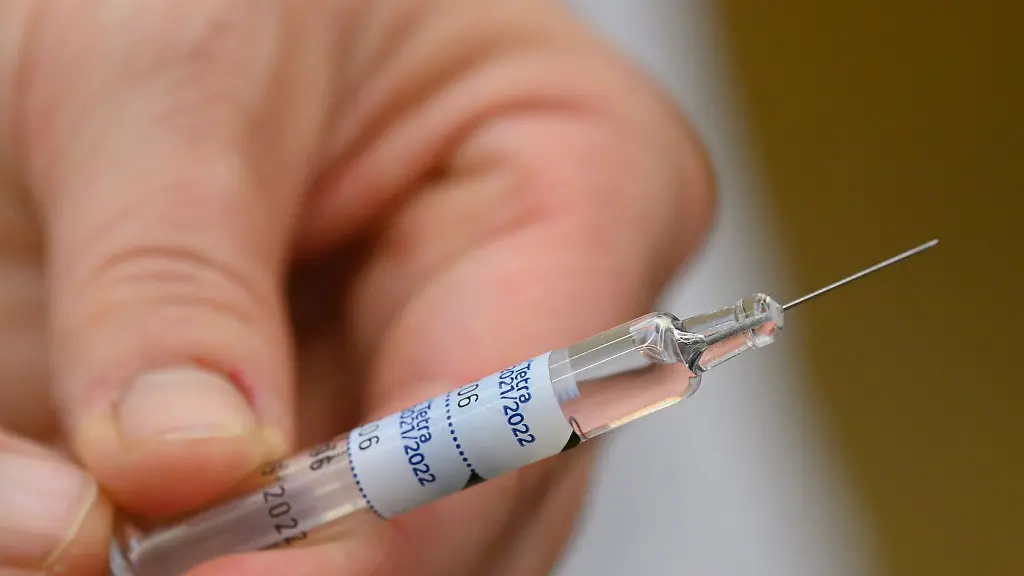 Eine-Aerztin-haelt-eine-Spritze-mit-einem-Wirkstoff-gegen-die-Grippe-in-der-Hand
