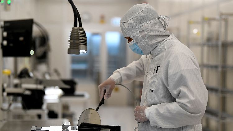 Ein Mitarbeiter arbeitet in Hamburg mit einem Wafer in einer Produktionslinie des niederländischen Halbleiterherstellers Nexperia. 