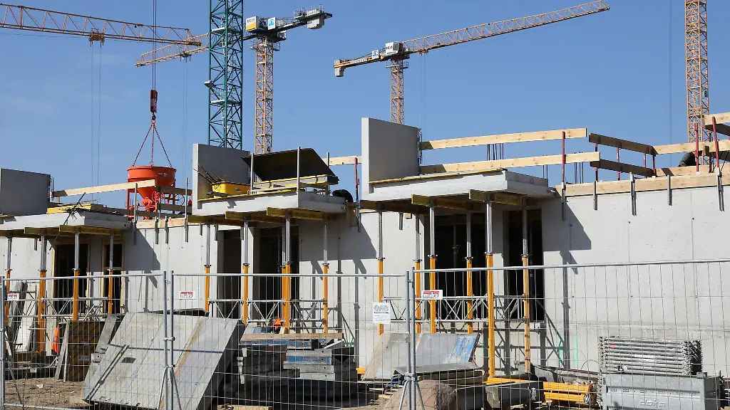 Kraene-und-Gerueste-stehen-auf-der-Baustelle-eines-Mehrfamilienhauses