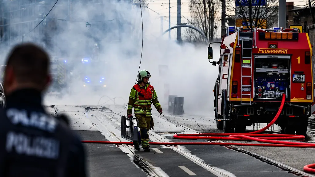 Ein-Feuerwehrmann-geht-waehrend-des-Einsatzes-rund-um-eine-Gasexplosion-in-der-Friedrichstadt-ueber-die-Strasse
