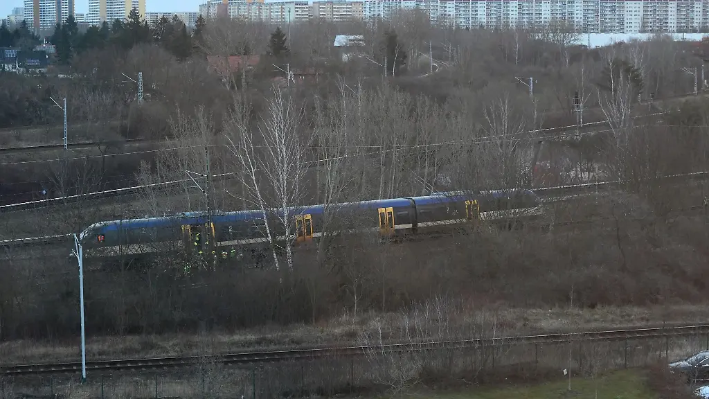 Einsatzkraefte-stehen-an-der-Regionalbahnstrecke-unweit-der-Gensinger-Strasse-in-Friedrichsfelde-Ein-Regionalzug-ist-nahe-dem-S-Bahnhof-Friedrichsfelde-Ost-mit-einer-herabhaengenden-Oberleitung-zusammengestossen