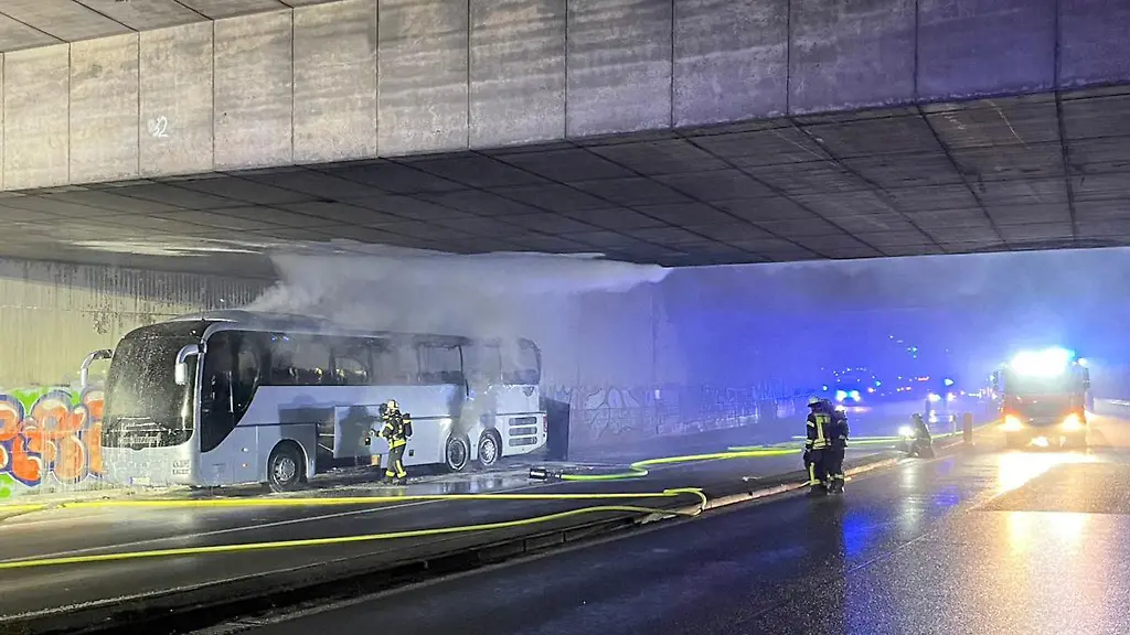 Feuerwehrleute-arbeiten-an-einem-brennenden-Reisebus-Der-Fahrer-bemerkte-nahe-der-Anschlussstelle-Bonn-Poppelsdorf-Rauch-und-Feuerschein-am-Bus-wie-die-Feuerwehr-mitteilte