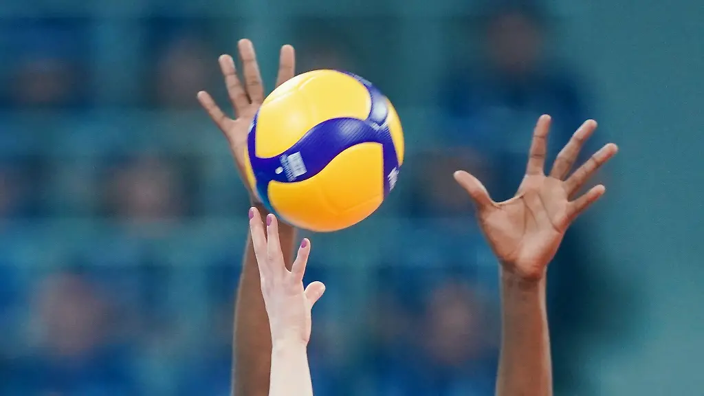 Spielerinnen-strecken-ihre-Arme-in-Richtung-eines-Volleyballs