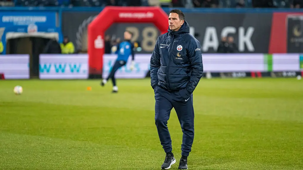 Rostocks-Trainer-Patrick-Gloeckner-steht-vor-dem-Spiel-auf-dem-Rasen