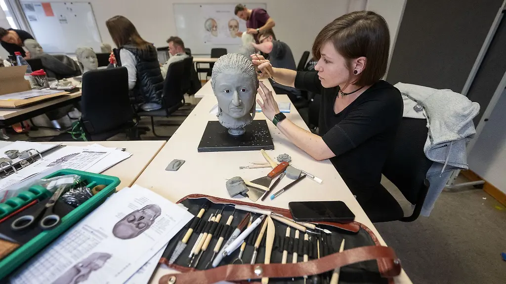 Eine-Teilnehmerin-modelliert-waehrend-eines-Workshops-einen-Phantom-Schaedel