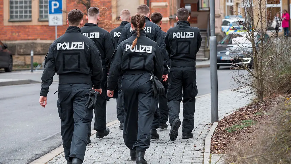 Einsatzkraefte-der-Polizei-suchen-das-Gebiet-um-das-Blumengeschaeft-ab