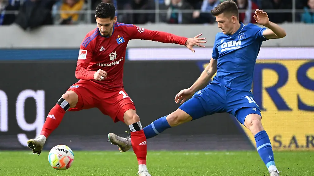 Der-Karlsruher-Marvin-Wanitzek-r-und-der-Hamburger-Ludovit-Reis-kaempfen-um-den-Ball