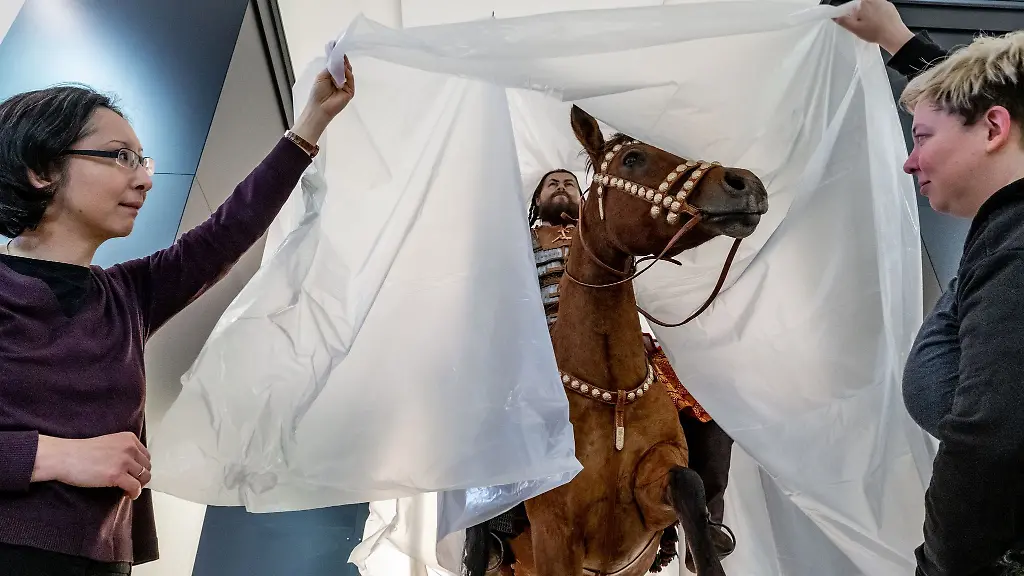 Tomoko-Emmerling-l-und-Josefine-Bedinger-werfen-einen-Blick-auf-die-Rekonstruktion-eines-awarischen-Reiterkriegers-aus-dem-Deri-Muzeum-Debrecen-in-Ungarn