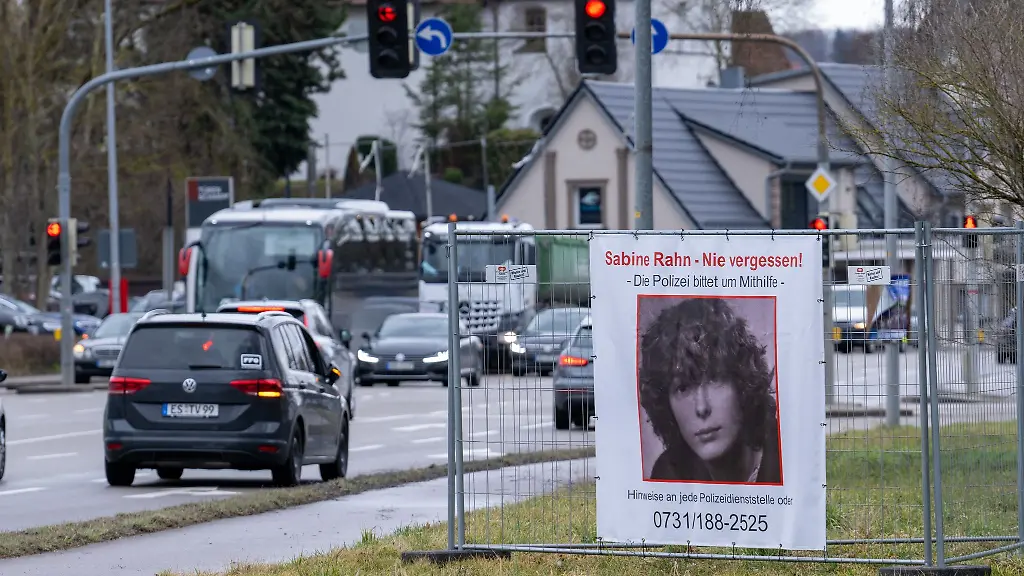 Autos-fahren-an-einem-Plakat-mit-der-Aufschrift-Sabine-Rahn-Nie-vergessen-vorbei