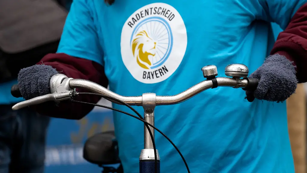 Eine-Vertreterin-des-Buendnisses-Radentscheid-Bayern-steht-mit-ihrem-Fahrrad-vor-dem-bayerischen-Innenministerium