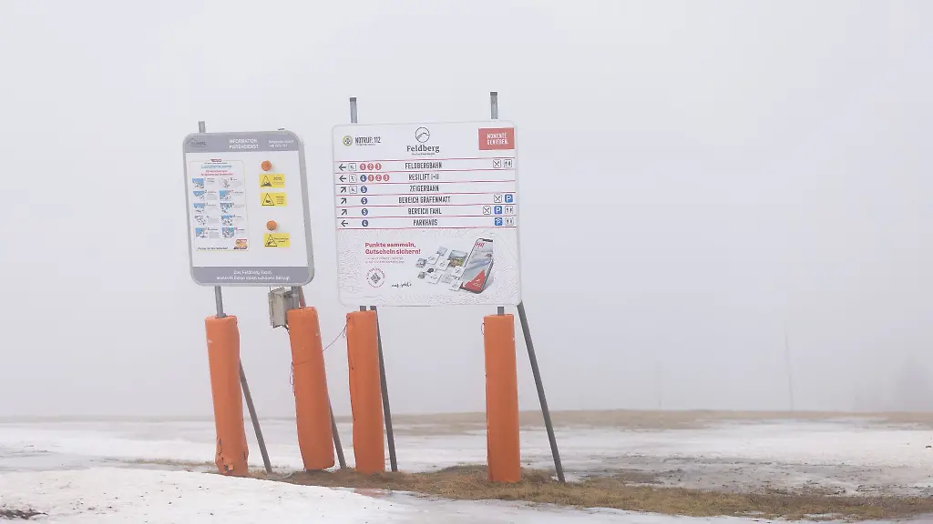 Hinweisschilder-fuer-Wintersportlerinnen-und-sportler-stehen-auf-dem-Gipfel-des-Feldberg