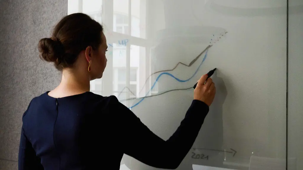 Eine-Frau-steht-an-einem-Whiteboard-in-einem-Konferenzraum