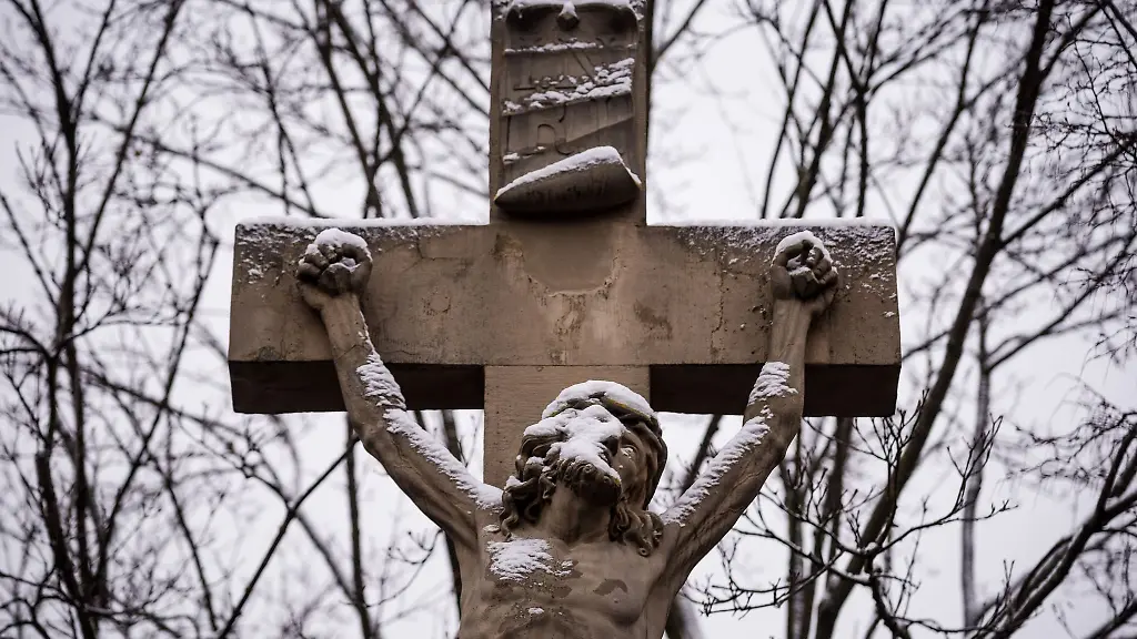 Eine-Figur-von-Jesus-am-Kreuz-ist-mit-Schnee-bedeckt