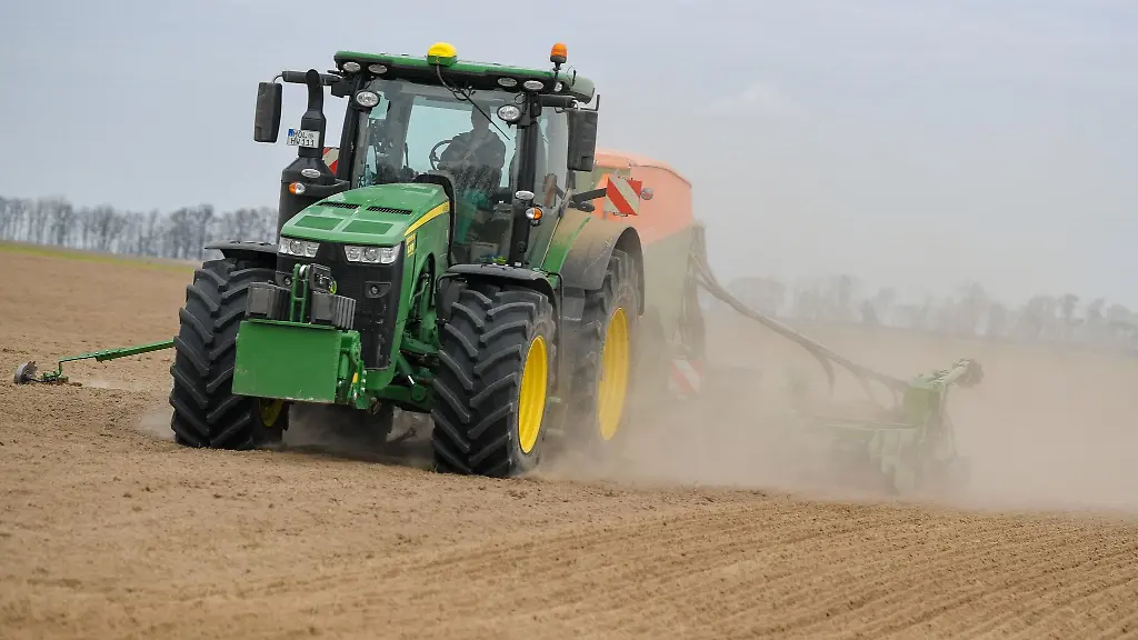 Auf-einem-Feld-wird-mit-einem-Traktor-in-den-trockenen-Boden-eine-Zwischenfrucht-zur-Bodenverbesserung-gedrillt