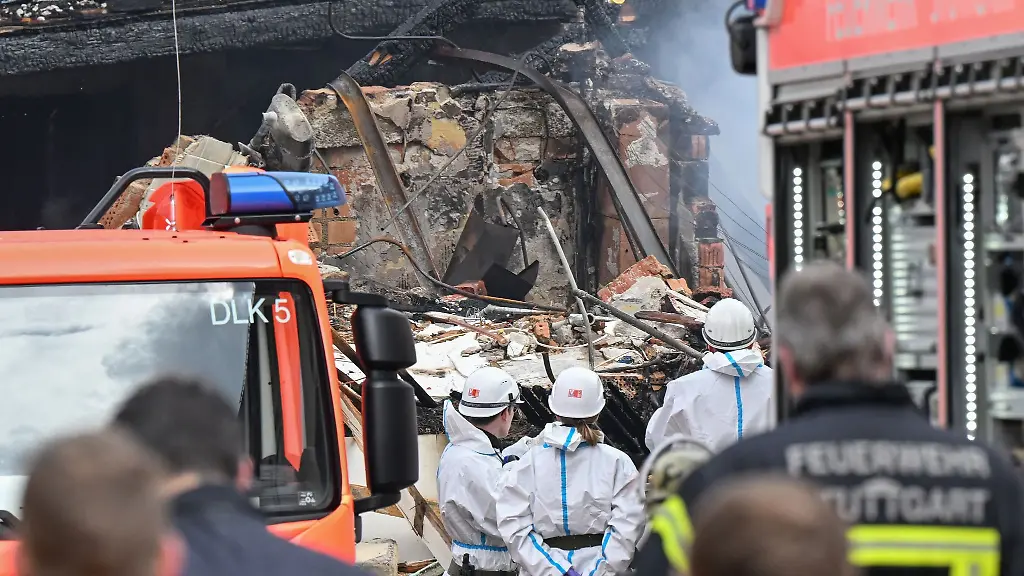 An-der-Ungluecksstelle-in-Stuttgart-West-loeschen-Feuerwehrleute-den-Brand