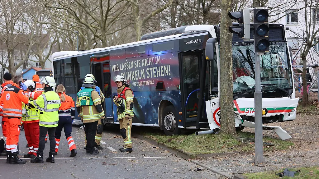 Rettungskraefte-stehen-an-einem-Linienbus-der-von-der-Fahrbahn-abgekommen-war