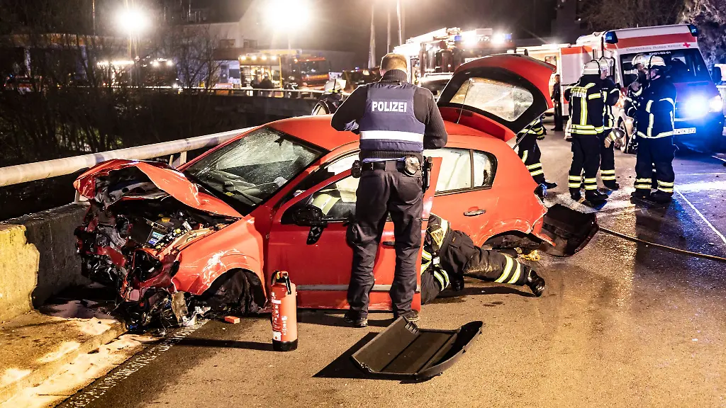Polizei-und-Feuerwehr-arbeiten-an-einer-Unfallstelle-nachdem-ein-Auto-mit-acht-Insassen-von-der-Strasse-abgekommen-ist-Alle-Insassen-wurden-verletzt-Der-Fahrer-und-ein-Mitfahrer-wurden-schwer-verletzt-wie-die-Polizei-am-Sonntagmorgen-mitteilte