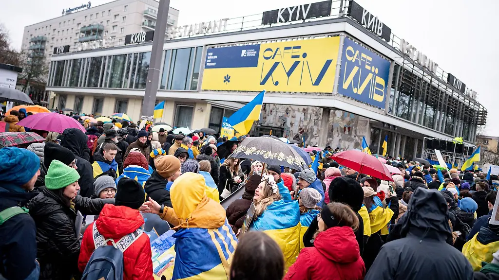 Teilnehmer-einer-Demonstration-unter-dem-Motto-Wir-werden-nie-vergessen-stehen-an-der-Karl-Marx-Allee-vor-dem-Cafe-Moskau-das-fuer-ein-paar-Tage-in-Cafe-Kyiv-Kiew-umbenannt-wurde