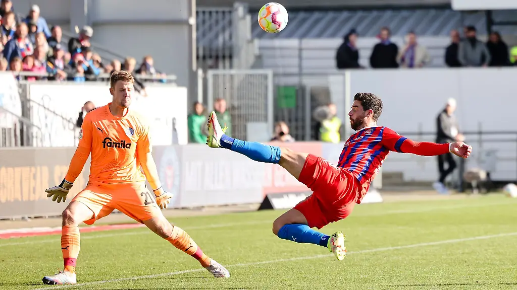 Heidenheims-Stefan-Schimmer-r-schiesst-gegen-Kiels-Torwart-Thomas-Daehne-ueber-das-Tor