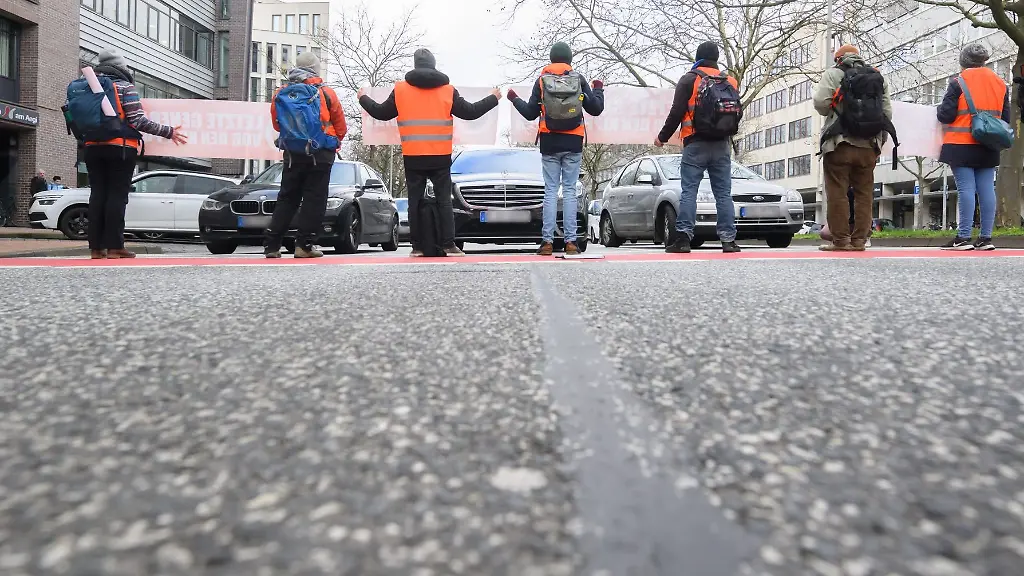 Aktivisten-der-Gruppierung-Letzte-Generation-blockieren-auf-der-Hildesheimer-Strasse-am-Aegidientorplatz-den-Verkehr