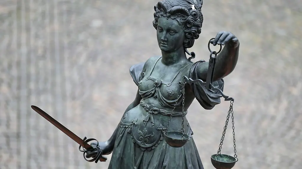 Eine-Statue-der-Justitia-haelt-eine-Waage-und-ein-Schwert-in-der-Hand