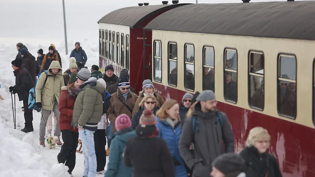 Besucher-stehen-auf-dem-Brocken-nachdem-ein-Zug-der-Harzer-Schmalspurbahnen-GmbH-den-Brockengipfel-erreicht-hat