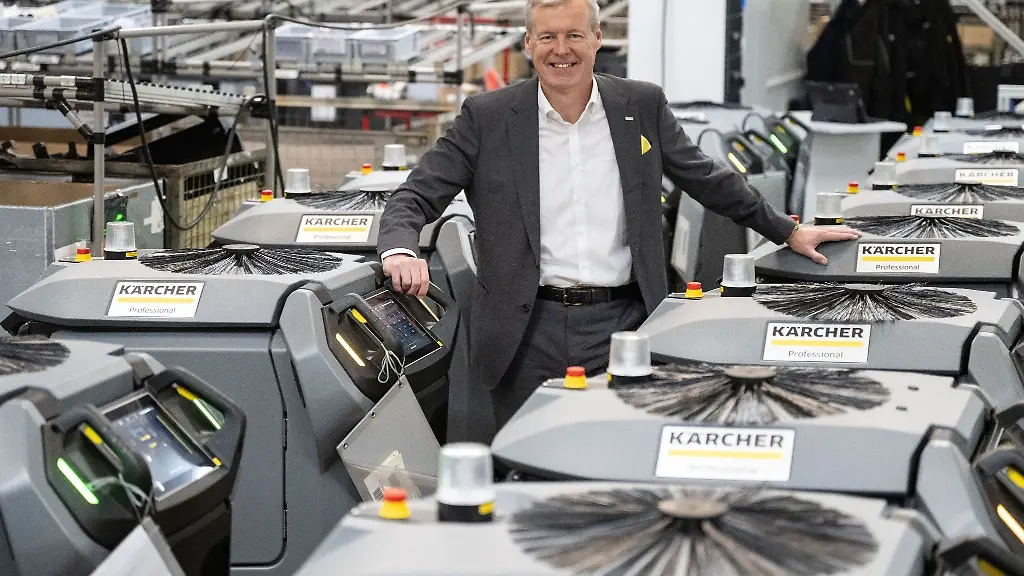 Hartmut-Jenner-Vorstandsvorsitzender-der-Alfred-Kaercher-SE-Co-KG-steht-zwischen-Kira-B-50-vollautonomen-Scheuersaugmaschinen