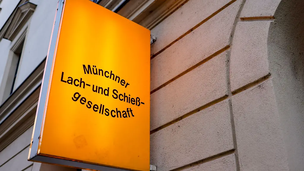 Ein-beleuchtetes-Schild-markiert-den-Eingang-zur-Lach-und-Schiessgesellschaft