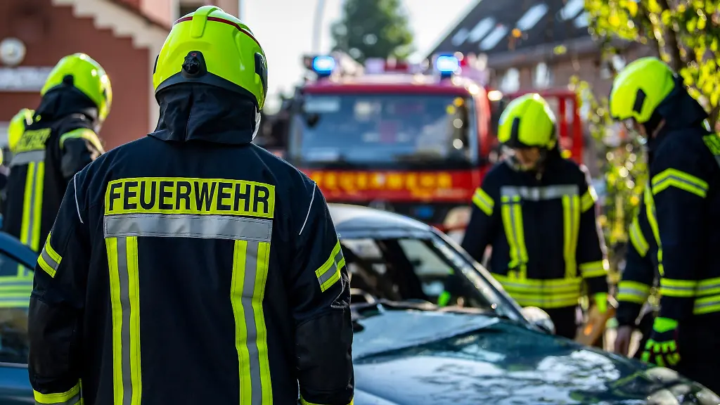 Feuerwehrleute-stehen-um-ein-Auto-das-einen-Unfall-gehabt-hat