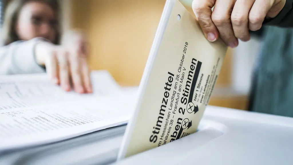 Eine-Waehlerin-wirft-ihren-Stimmzettel-fuer-eine-Landtagswahl-in-Hessen-in-die-Wahlurne