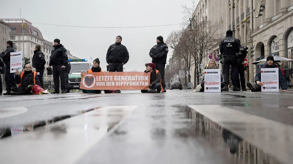 Mitglieder-der-Umweltschutz-Gruppe-Letzte-Generation-blockieren-eine-Kreuzung-auf-der-Strasse-Unter-den-Linden